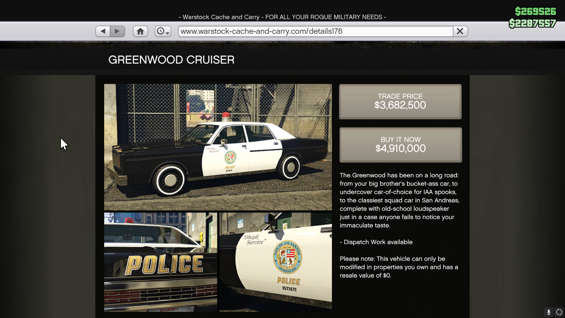 A black and white classic police car against a chain link fence